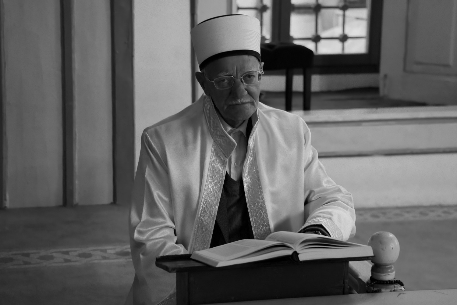 Cheikh assis devant un Coran