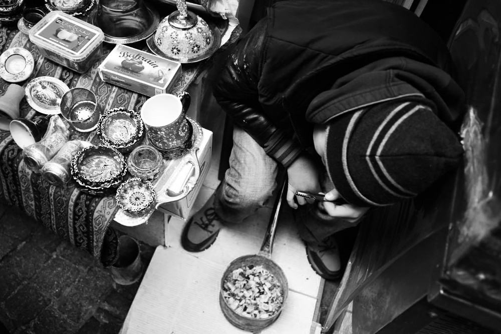 Marchand de rue à Istanbul, penché sur un tison