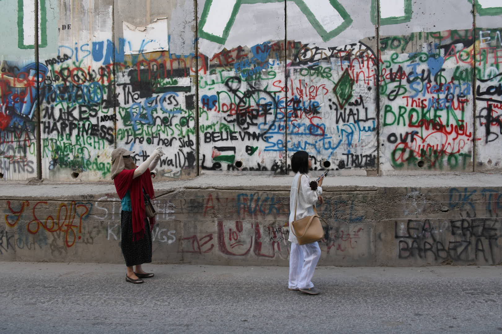 Touristes asiatiques photographiant le mur de séparation entre Israël et les Territoires palestiniens