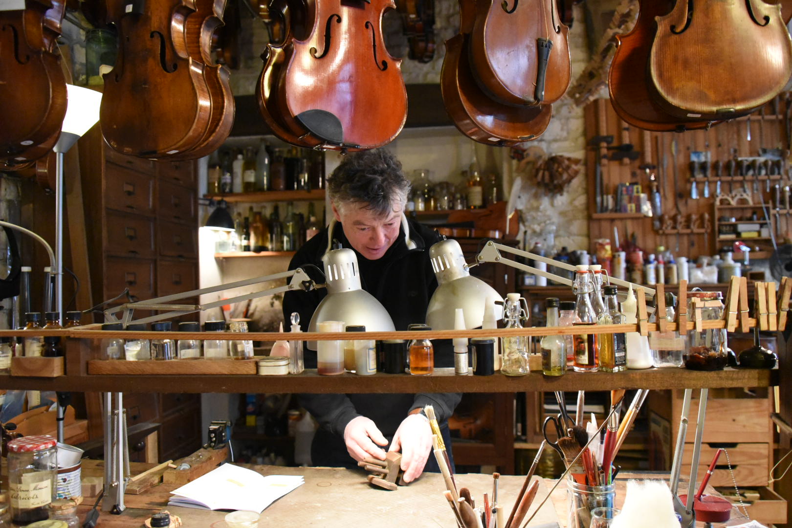 un homme fabrique des violons
