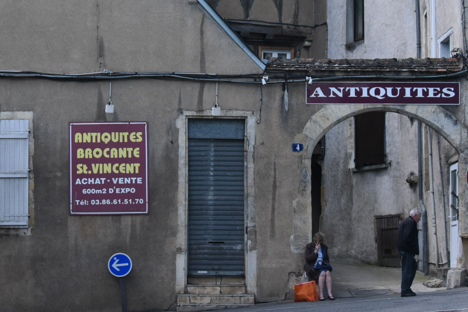 Deux personnes âgées devant une enseigne d'antiquités